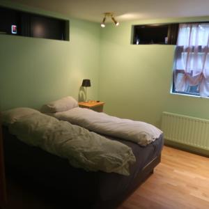 two beds in a room with a lamp and a window at Large apartment close to the centre in Reykjavík