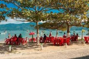 un grupo de personas sentadas en mesas en la playa en CASA DA ANA E ZÉ, en Governador Celso Ramos