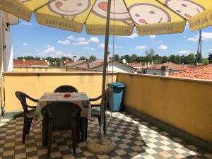 einen Tisch und Stühle auf einem Balkon mit Sonnenschirm in der Unterkunft Residence Flavia in Mogliano Veneto