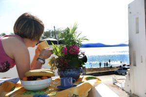 a woman sitting at a table with a bowl of food at Ilion Hotel in Naxos Chora