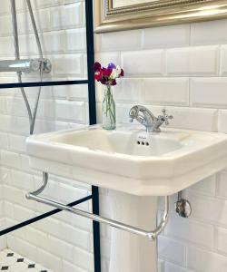 ein weißes Waschbecken im Bad mit einer Blumenvase in der Unterkunft Villa Vintage B&B in Nauvo + 52 Fotos