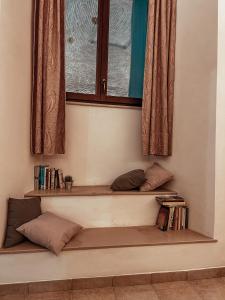 estante con almohadas y ventana en una habitación en VadoLibera House en LʼAquila