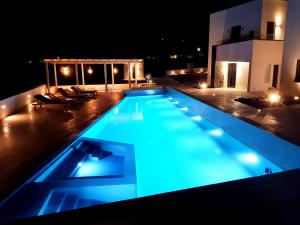a swimming pool lit up at night at myLithos Suites in Monolithos