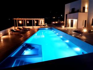 una piscina illuminata di notte di myLithos Suites a Monolithos