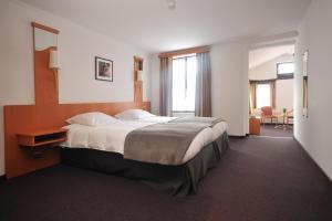 una camera da letto con un letto grande con testiera in legno di Hôtel du Perron a Theux