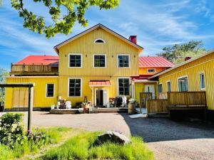 una casa amarilla con techo rojo en Villa Vintage B&B en Nauvo