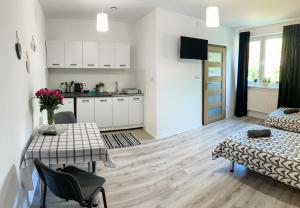 a kitchen and a living room with a table and chairs at Agroturystyka Mazal Dukla in Dukla