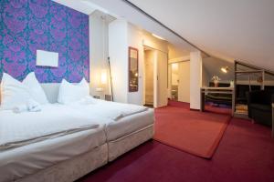 a bedroom with a large bed and a living room at AMADEA - Cityhotel Salzburg in Salzburg