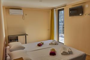 a bedroom with two beds with towels and a window at Villa Story Hotel in Shekhvetili