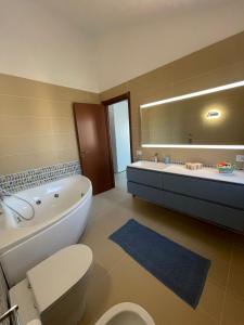 a bathroom with a tub and a toilet and a sink at Penthouse Le Isole - Luxury rooftop retreat in Marsala +26 photos
