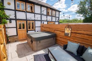 a backyard with a wooden fence and a hot tub at Apple Tree Cottage - Cosy 2 Bed with Deluxe HOT TUB & Log Burner in Hereford