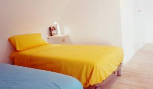 1 dormitorio con 1 cama con manta amarilla en Casa Gastronomo en Procida