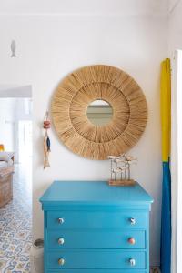 un espejo en una pared sobre una cómoda azul en Casa Gastronomo en Procida