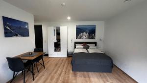 a bedroom with a bed and a desk and a table at Studio11 in Neustift im Stubaital