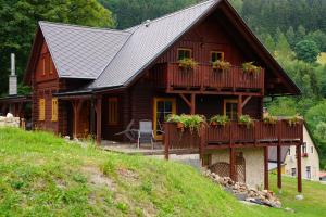 a log cabin with a balcony with flowers on it at Rodinný dům na Sluneční stráni in Dolni Dvur