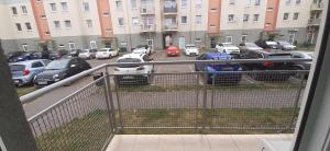 a balcony with cars parked in a parking lot at Apartament Paderewski in Oleśnica