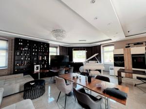 a living room with a table and a piano at Wilson Paradise Guest House in Thenneberg