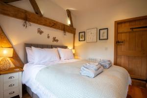 a bedroom with a bed with towels on it at Apple Tree Cottage - Cosy 2 Bed with Deluxe HOT TUB & Log Burner in Hereford