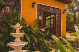 a garden with a fountain in front of a house at Villaflor Pousada in Vale do Capao