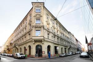 un grande edificio con macchine parcheggiate di fronte di View to the Roofs Luxury Apartment with 2 Bedrooms a Budapest