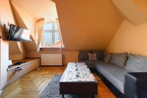 un soggiorno con divano e TV di View to the Roofs Luxury Apartment with 2 Bedrooms a Budapest