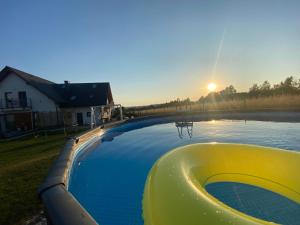 duży basen w ogrodzie z zachodem słońca w obiekcie Liliowy Apartament w Kudowie Zdroju