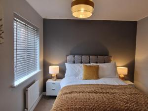 a bedroom with a large bed and two lamps at Norwich, Lavender House, 3 Bedroom House, Private Parking and Garden in Norwich