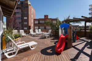 un parque infantil con tobogán y sillas en una terraza en Medamar Club en Villa Gesell