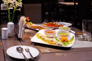 Jalchhabi Hotel & Resort في Lālbāgh: طاولة مع أطباق من الطعام على طاولة