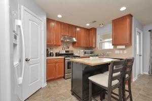 a kitchen with wooden cabinets and a kitchen island at Early Green Home Sleeps 6 Yard King Suite in Houston +16 photos
