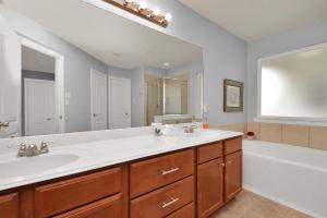 a bathroom with a sink and a tub and a mirror at Early Green Home Sleeps 6 Yard King Suite in Houston