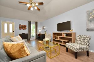 a living room with a couch and a tv at Early Green Home Sleeps 6 Yard King Suite in Houston