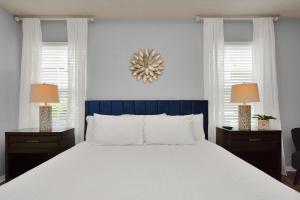 a bedroom with a large bed and two windows at Early Green Home Sleeps 6 Yard King Suite in Houston