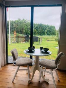a table and two chairs in front of a window at Droom aan de Linge in Wadenoijen