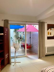 Cette chambre dispose d'une terrasse avec un parasol rose. dans l'établissement ART'APPART, à Narbonne