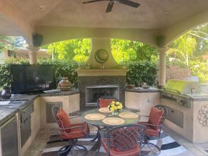 un patio con mesa, sillas y chimenea en Tuscany Dorado Resort en Cameron Park