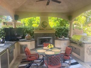 Cameron ParkTuscany Dorado Resort的带桌椅和壁炉的露台