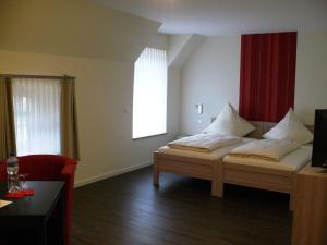 um quarto com uma cama com almofadas brancas em Gästehaus Fraune em Salzkotten
