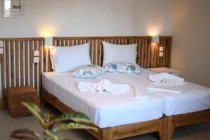 a large white bed with two towels on it at Villa Fantasia in Skiathos