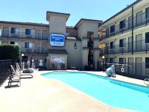 a hotel with a swimming pool in front of a building at Rodeway Inn Sacramento-University Area in Sacramento