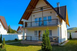 a large white house with a gambrel roof at Oaza Mira Hotel & Resort-فندق ومنتجع واحة الهدوء in Vlasic