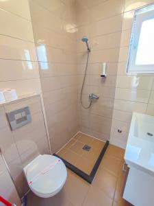 a bathroom with a toilet and a shower at Oaza Mira Hotel & Resort-فندق ومنتجع واحة الهدوء in Vlasic +37 photos