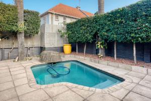 a swimming pool in the middle of a yard at Hampton Collection - Stylish 3 Sleeper Apartment with Pool in Durban