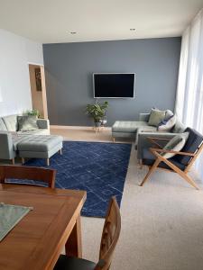 a living room with couches and a flat screen tv at Luxury 3 bdm Spacious apt in the heart of Wagga in Wagga Wagga