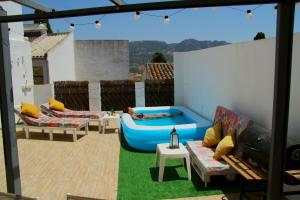 a rooftop patio with a hot tub and lounge chairs at Spa, Sierra y sol in Cortes de la Frontera