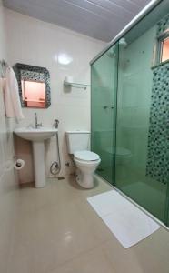 a bathroom with a toilet and a glass shower at Pousada Flor De Lótus Cipo in Serra do Cipo