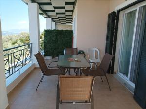 eine Terrasse mit einem Tisch und Stühlen auf dem Balkon in der Unterkunft To Ampelaki in Tsoukaladhes
