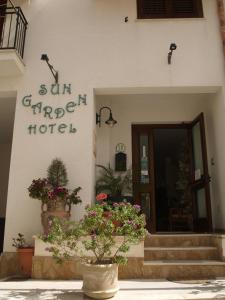 um hotel com flores em frente a um edifício em Sun Garden em San Vito lo Capo