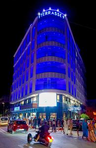 un edificio azul con gente caminando delante de él en Hôtel La Perla, en Alhucemas