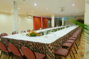 Hexagon International Hotel, Villas & Spa في نادي: طاولة طويلة في غرفة مع كراسي وطاولة طويلة
